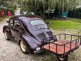 a brown car with a trailer attached to the back of it