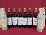 six bottles of wine are lined up in a row on a table