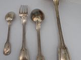 four silver spoons and a fork on a white surface