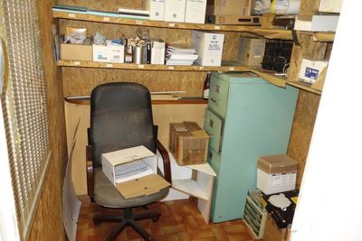 a chair that is sitting in a room with boxes on the shelves