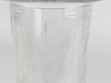 a glass vase with a silver lid on a white surface