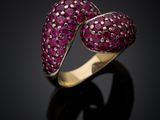 a close up of a ring with pink stones on a black surface