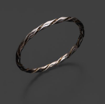 un gros plan d'une bague en argent tordue sur fond noir