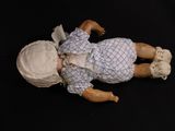 a small doll that is laying down on a black surface