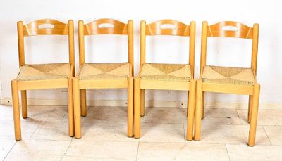 Quatre chaises en bois sont alignées contre un mur dans une pièce
