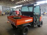 a small orange utility truck parked inside of a building