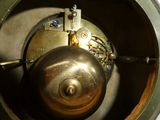 un gros plan d'une horloge en métal munie d'une cloche