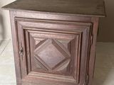 un petit meuble en bois surmonté d'une porte