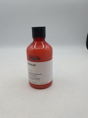 une bouteille contenant un liquide rouge posée sur une surface blanche