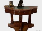 une statue de femme assise sur une table à côté d'une horloge