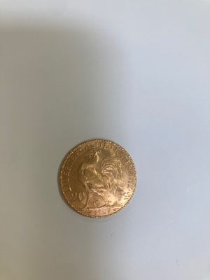 une pièce d'or posée sur une assiette blanche