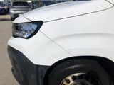 a white van parked in a parking lot with other cars in the background