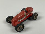 a red toy car that is sitting on a white surface