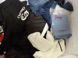 a pile of clothes that is sitting on a bed