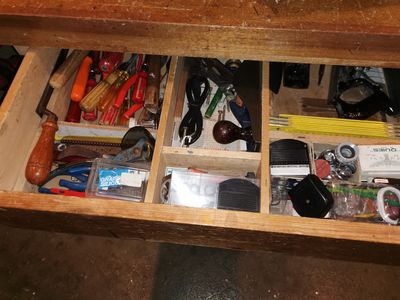 un tiroir rempli d'objets, posé sur une table