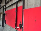 a red wall that has a bunch of hooks on it