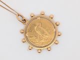 une image représentant un pendentif en forme de pièce d'or sur lequel figure un oiseau