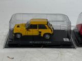 two toy cars in a display case on a white surface