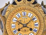 a gold and blue vase with a clock on top of it