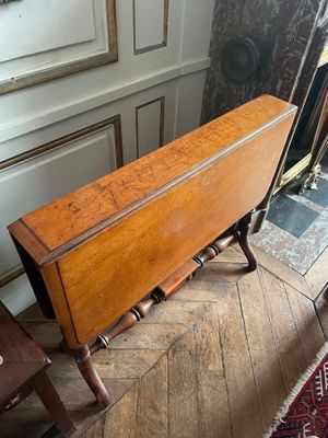 a small table with a wooden top on a wooden floor