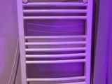 un porte-serviettes blanc orné d'une lumière violette