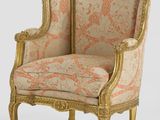 un fauteuil rembourré doré et rose sur fond blanc