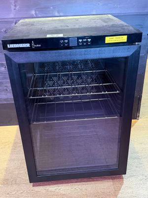 a small black oven with a glass door on the floor