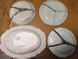 four white plates with a black ribbon around them on a wooden table