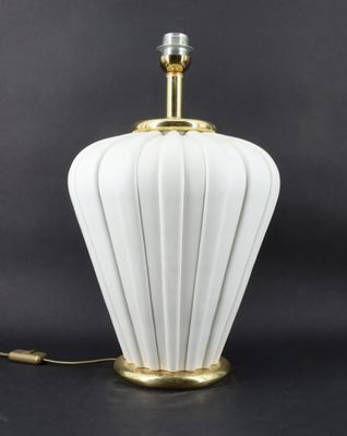 une lampe de table blanche et dorée avec un abat-jour en verre blanc