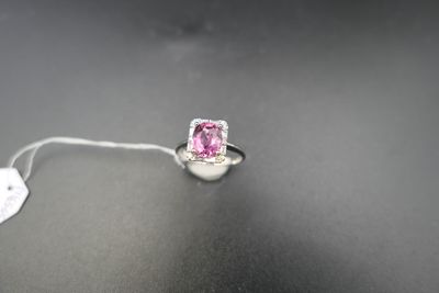 a close up of a pink diamond ring on a black surface