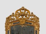 a mirror that has a gold frame with flowers and leaves on it