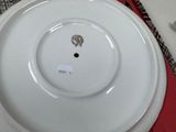 a white plate with a picture on it sitting on a red place mat