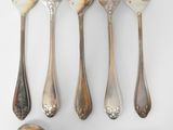six forks and spoons are arranged in a row on a white surface
