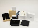 a lot of jewelry in boxes on a white surface