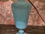 a blue glass lamp that is on a table