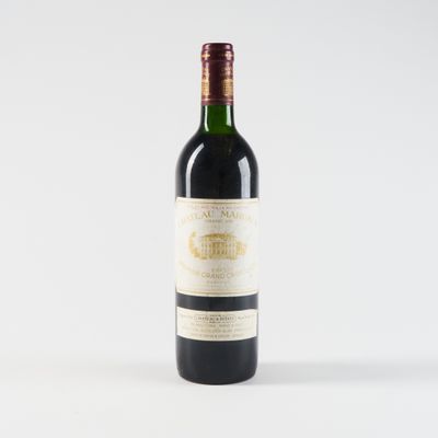 une bouteille de vin rouge posée sur une table blanche