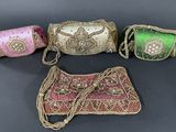 three small purses are lined up on a black surface