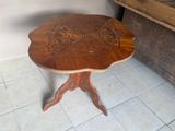 une petite table avec un plateau en bois sur un sol carrelé