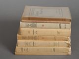 several old books stacked on top of each other on a table