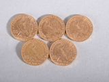 four gold coins sitting on top of each other on a white surface
