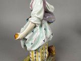 a figurine of a woman sitting on top of a rock