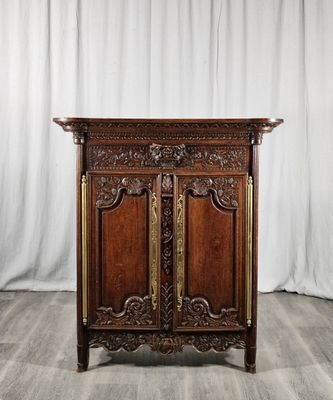une vieille armoire en bois avec des sculptures et des gravures sur les portes