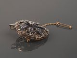 a close up of a gold and diamond broochle on a black surface