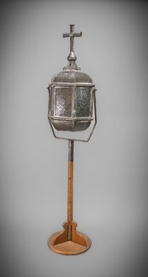 an image of a metal lantern on a wooden stand on a gray background