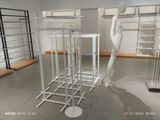a white mannequin standing next to a rack of clothes
