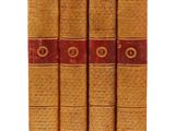 trois livres sont alignés sur une surface blanche