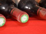 several bottles of wine are lined up on a red cloth