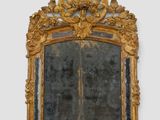 a mirror with a gold frame on the wall