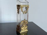 un vase en verre avec une horloge posé sur une table