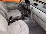 a small orange car that is parked in a lot